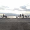 Spiaggia deserta con ombrelloni chiusi.