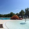 Piscina all'aperto con scivolo e lettini.