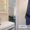 Bagno con lavabo bianco e accappatoio blu appeso.