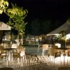 Patio esterno con tavoli illuminato di notte.
