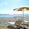 Due lettini e un ombrellone su una spiaggia sabbiosa.