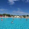 Piscina all'aperto con scivolo e ombrelloni.