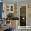 Interno di una casa mobile con un angolo cucina e soggiorno arredati.