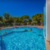 Piscina con bagnanti e ambiente verde.