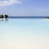 Piscina a sfioro con vista sul mare e cielo sereno.