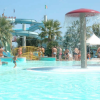 Piscina con giochi acquatici e persone che si divertono.