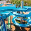 Scivolo d'acqua blu con curve, circondato da palme.