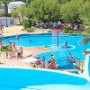 Piscina circolare con fontana centrale e bagnanti intorno.