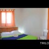 Camera da letto con letto matrimoniale, tendaggi arancioni e un piccolo comodino.
