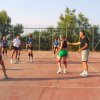 Persone giocano a pallavolo su un campo all'aperto.