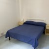 Camera con letto matrimoniale blu e due comodini con lampade.