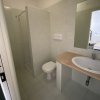 Un bagno con doccia, WC, lavabo e grande specchio.