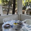 Veranda con tavolo apparecchiato e sedie bianche.