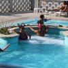 Piscina con persone che nuotano e prendono il sole.