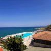 Vista su piscina e mare con cielo blu.