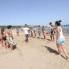 Gruppo di persone in spiaggia, partecipando a un'attività di gruppo, vicino all'acqua.