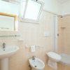 Bagno moderno con doccia, lavabo, bidet e finestra aperta.
