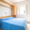 Camera da letto con letto matrimoniale e lenzuola blu, finestra aperta.