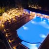 Piscina illuminata di notte con zona relax.