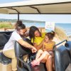 Famiglia su golf cart vicino alla spiaggia.