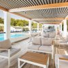 Un'area relax coperta con divani accanto alla piscina.