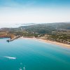 Panorama costiero con spiaggia e mare azzurro.