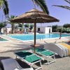 Piscina all'aperto con lettini e ombrelloni.