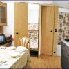 Cucina con tavolo apparecchiato, televisione e porta aperta verso altra stanza.