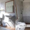 Un bagno con wc, lavandino, bidet e una doccia con piastrelle grigie.