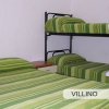Camera con letto matrimoniale e letto a castello, entrambi con coperte verdi.